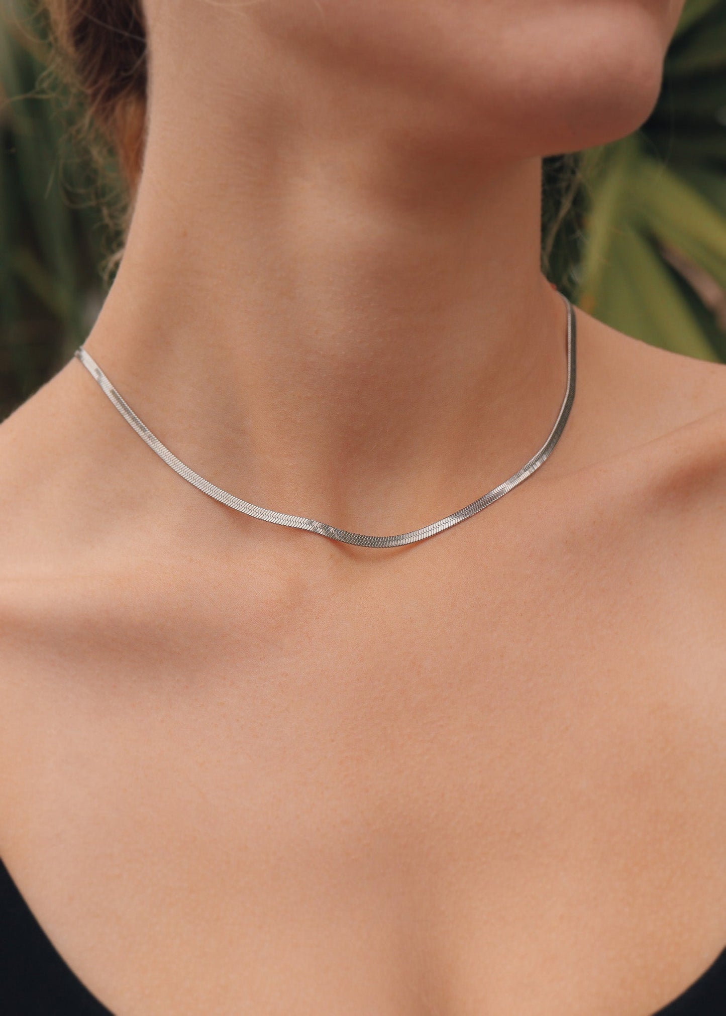 Silver necklace on a person with a blurred background