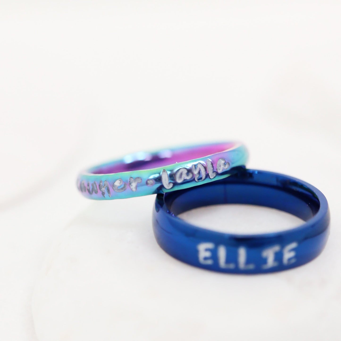 Two rings, one blue and one multicolored, on a white background.