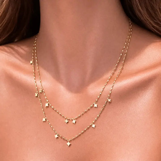 Gold necklace on a person's neck with a plain background