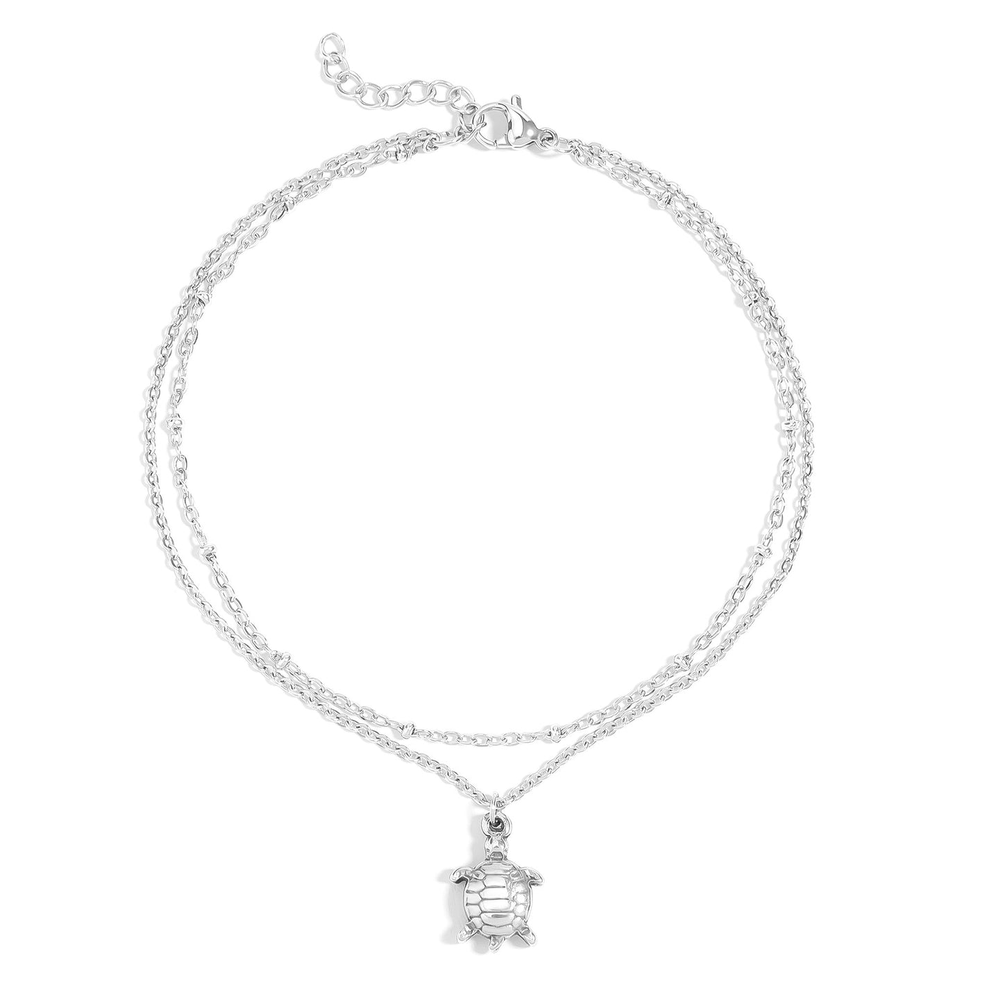 Silver layered anklet with sea turtle charm on a white background