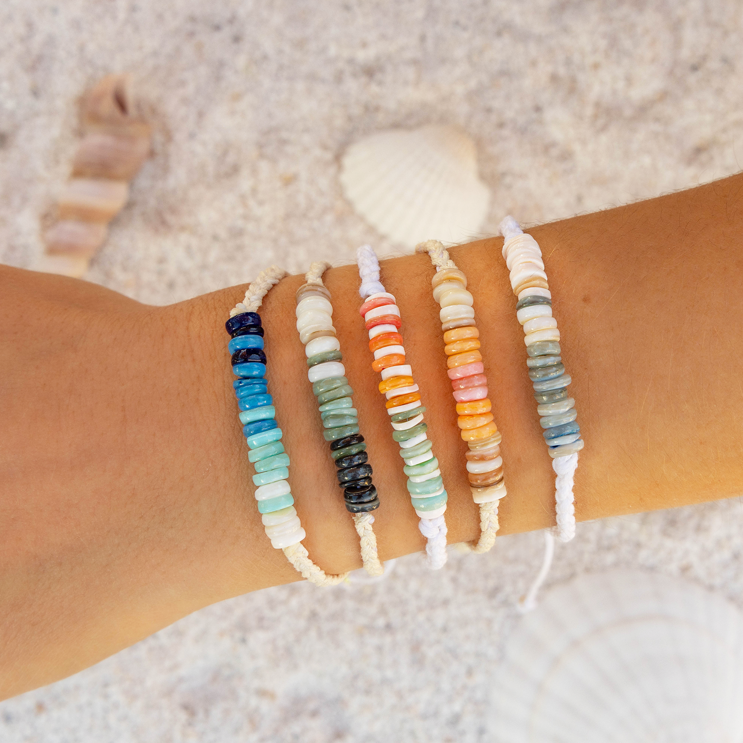 Set of beaded bracelets on a wrist with a beach background