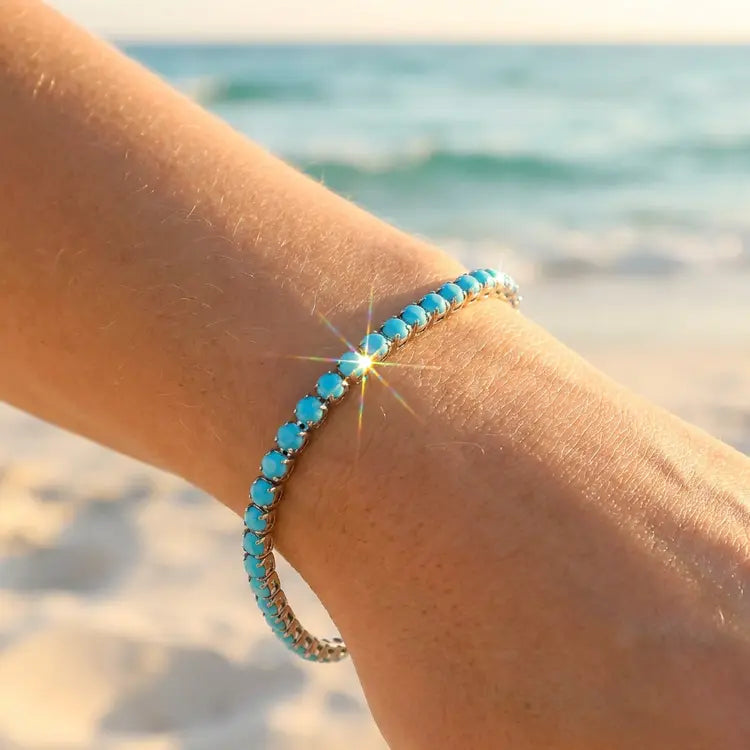 Turquoise beaded bracelet on a wrist with a beach background