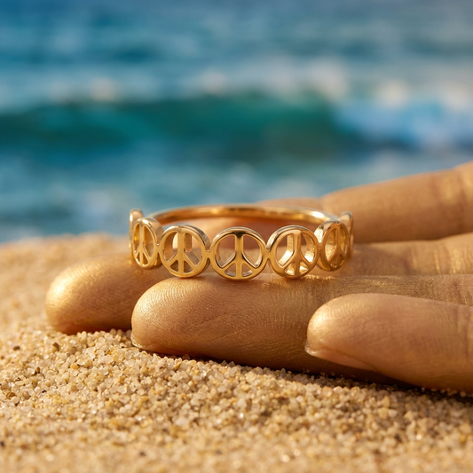 Gold peace sign ring on a hand with ocean background