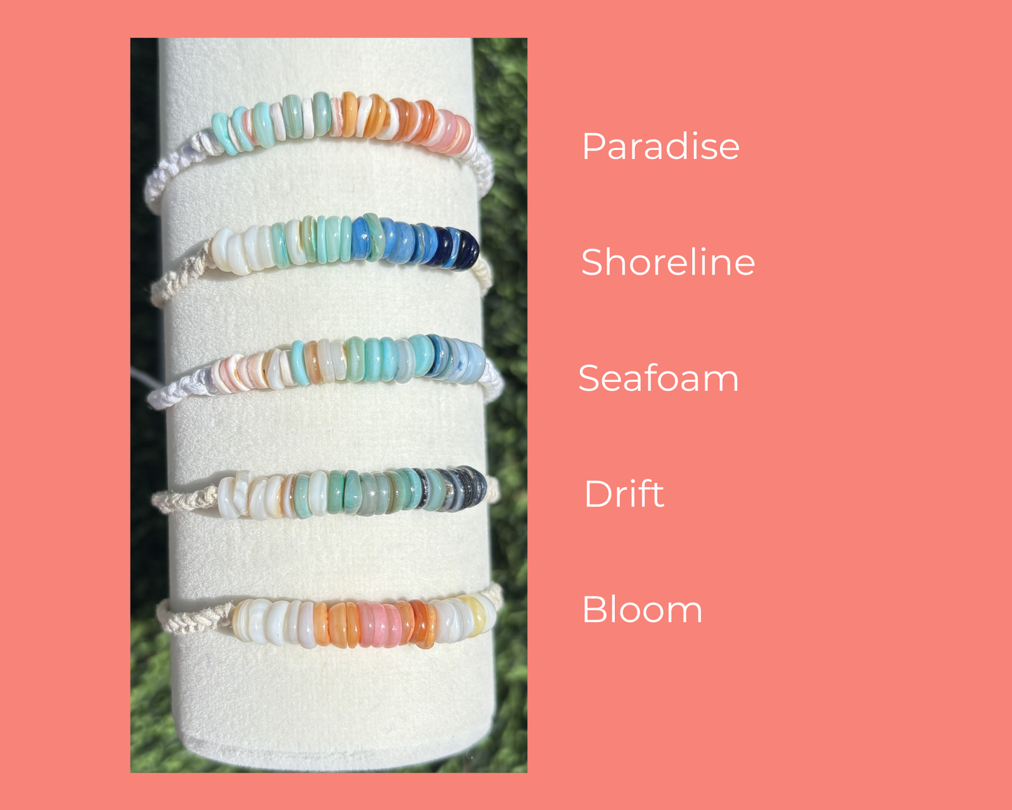 Set of colorful beaded bracelets on a white cylindrical stand with color names on a pink background.