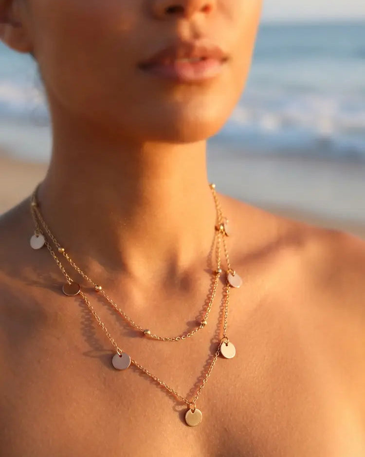 Woman wearing a layered necklace on a beach