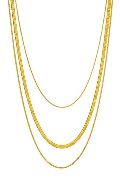 Three gold necklaces of different thicknesses on a white background