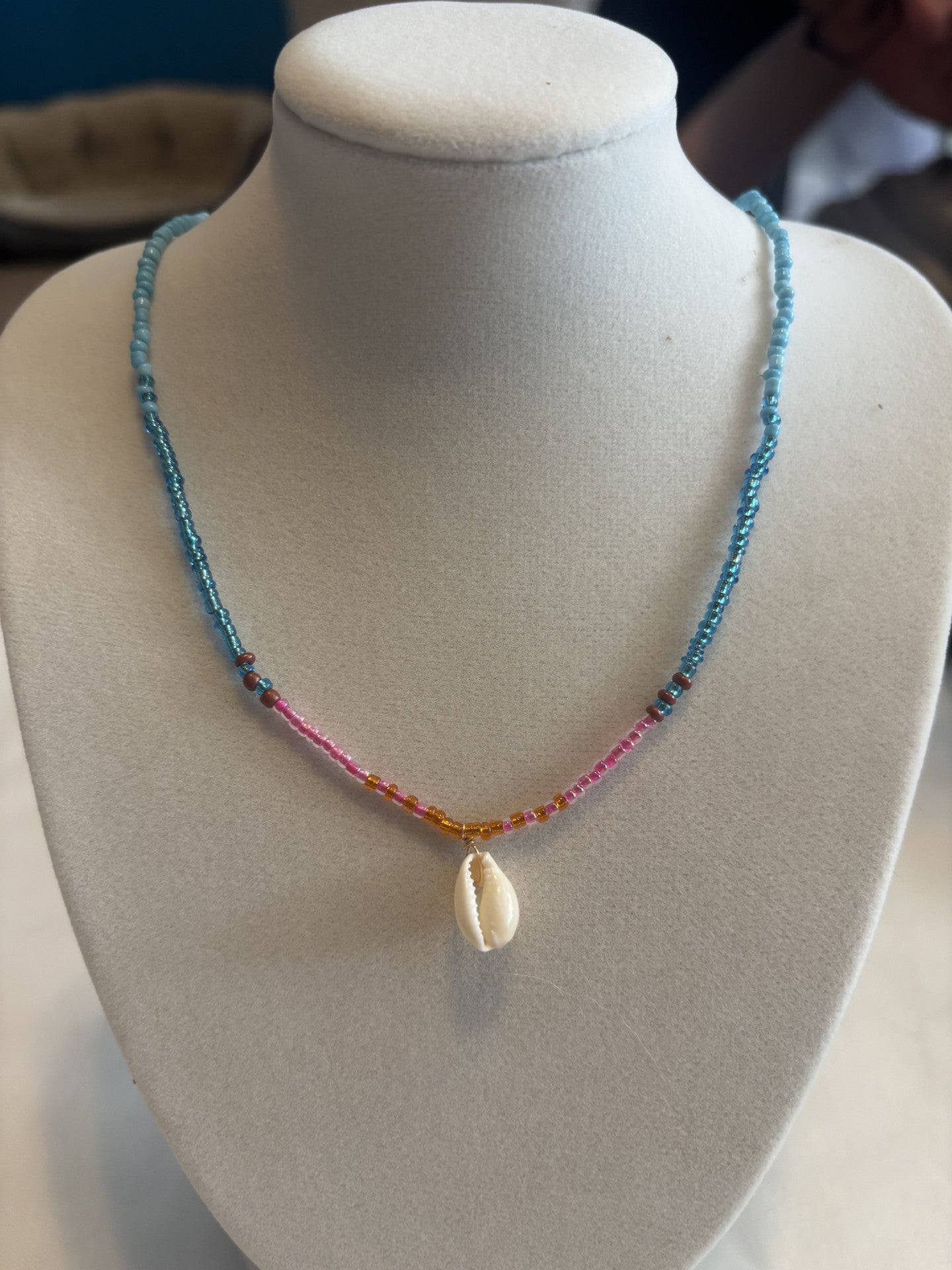 Necklace with a shell pendant on a mannequin bust