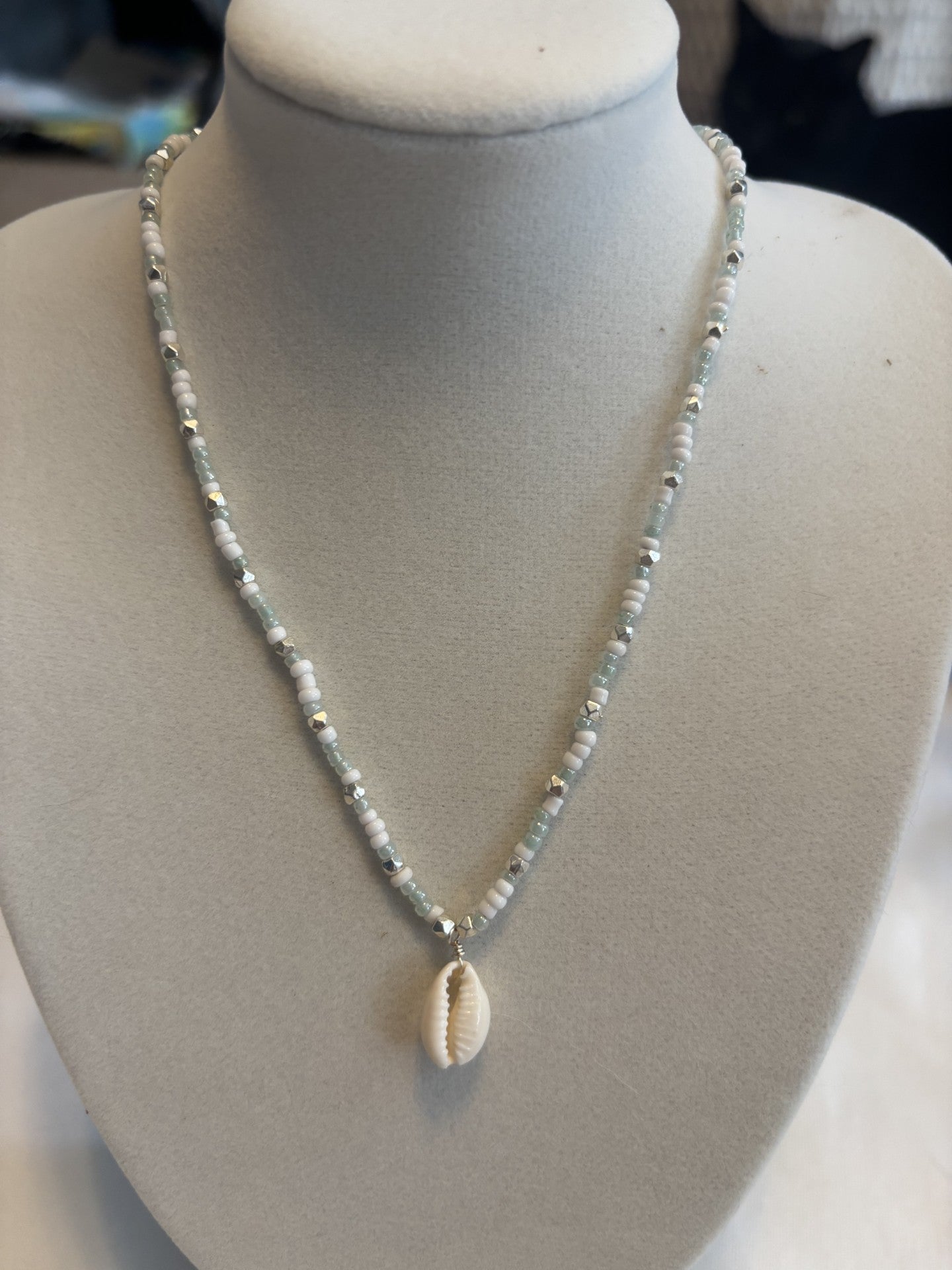 Necklace with a shell pendant on a mannequin bust